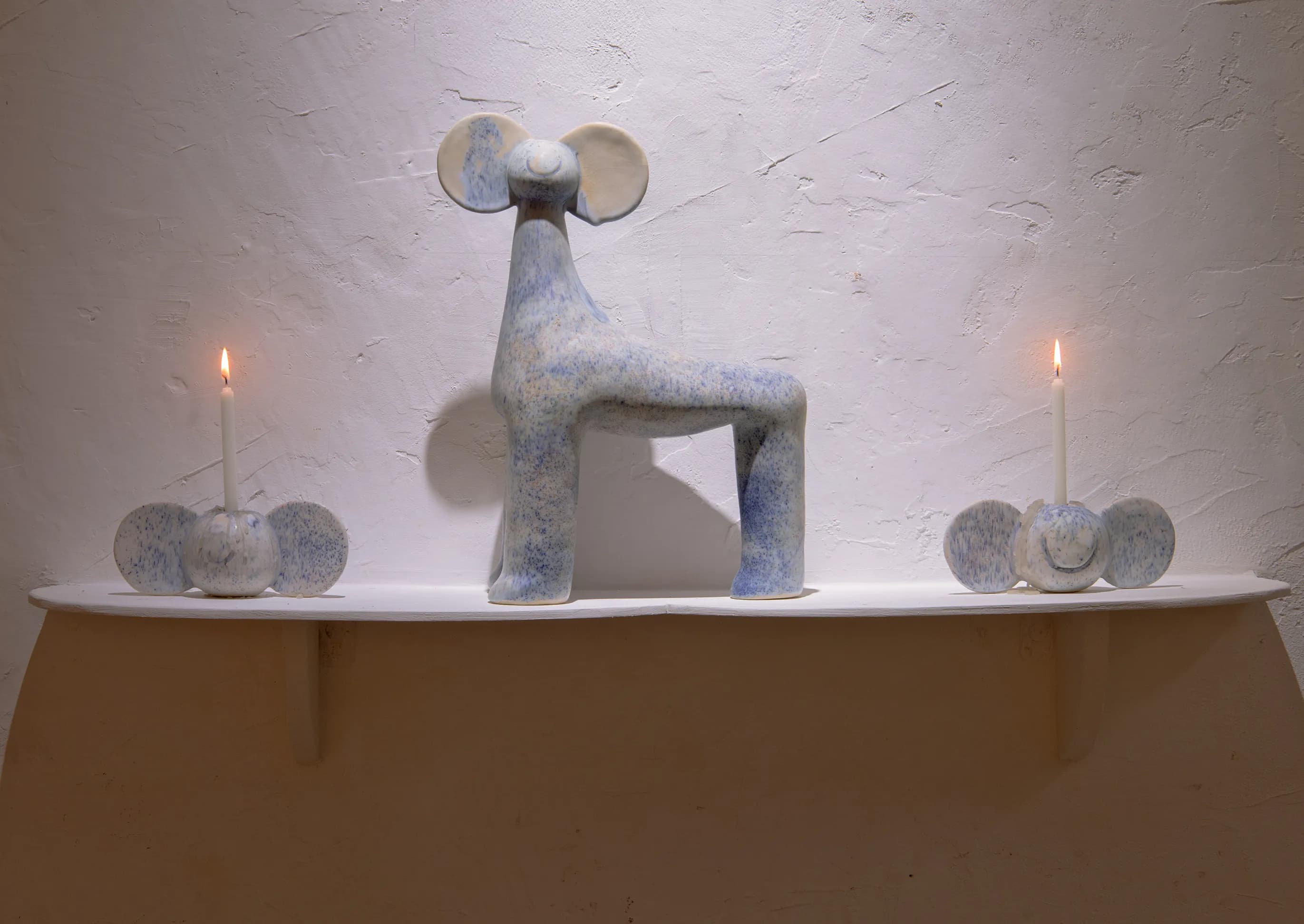 Detail of a twisted blue and white ceramic sculpture of an abstract two-legged figure